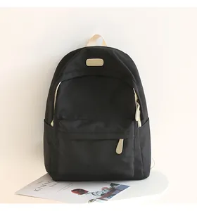 Detail of waterproof Oxford backpack showing premium black fabric and white handle contrast