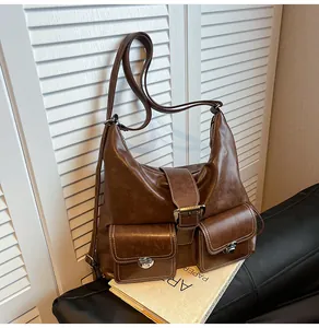 Detail of vintage brown PU leather crossbody bag with silver buckles and large front pockets