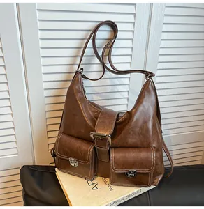 Close-up of vintage brown Hobo bag with front flap pockets and white stitching details