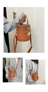 Details der Webstruktur dieser braunen Beuteltasche mit goldenen Reißverschlüssen