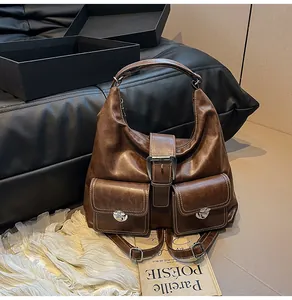 Macro detail of dark brown vintage leather backpack with silver buckles and contrast stitching