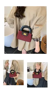Close-up of wine red quilted handbag featuring a golden turn-lock and leather chain strap