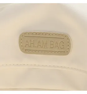 Detailed macro view of the AH.AM BAG rubber logo on a waterproof oxford fabric backpack