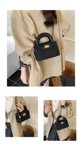 Close-up of quilted suede texture and gold twist-lock on stylish black crossbody bag