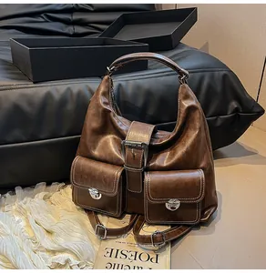 Detail of dark brown vintage leather tote with white contrast stitching and front pockets