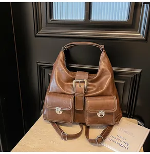 Detail of vintage brown leather tote bag with silver metal buckles and contrast stitching