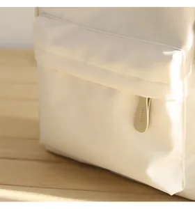 Macro detail of waterproof Oxford backpack with cream fabric texture and leather zipper pull