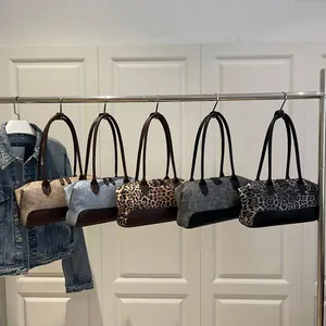 Boston-tassencollectie met diverse patronen en kleuren op een metalen displaystandaard