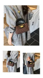 Close-up of brown quilted bag with black handle, gold lock and metallic chain