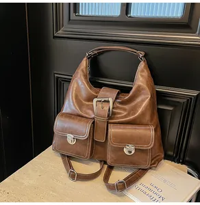 Detail of brown vintage leather bag with contrast stitching and silver metal buckles