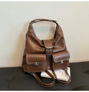 Detail of vintage brown leather bag showing white contrast stitching and silver buckles