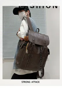 Makroaufnahme des braunen Vintage-Lederrucksacks mit Schnallen und Bärenanhänger
