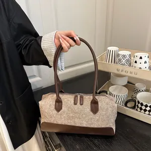 Detail van Boston-tas met contraststoffen en lederen stiksels met dubbele ritsen erop