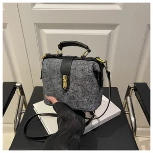 Detail of grey quilted handbag featuring gold metal clasp and premium fabric texture