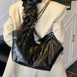Quilted black faux leather tote bag with gold chain strap and turn-lock closure