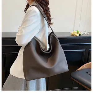 Bolso tote de cuero chocolate con correa ancha mostrado en una vista de hombro casual