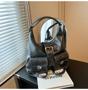 Close-up of black leather tote bag with utility pockets and metallic twist locks