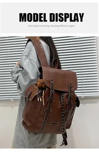 Detailansicht eines braunen Vintage-Lederrucksacks mit Kontrastnähten und Bärenanhänger