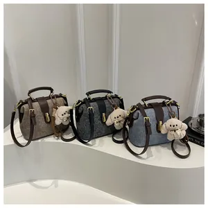 Three elegant doctor bag style handbags in tweed texture with gold clasps and plush charms