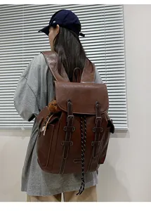 Detail eines dunkelbraunen Vintage-Rucksacks mit verstellbaren Schnallen und Kordelzug