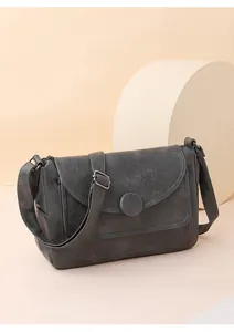 Dettaglio borsa a tracolla retrò grigio scuro in ecopelle martellata con fibbia tonda