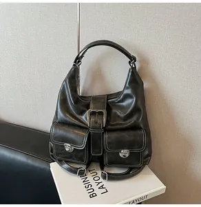 Detail of vintage black PU leather bag with white contrast stitching and silver buckles