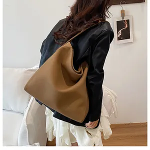Vista lateral de un gran bolso tote marrón llevado por una modelo con estilo casual chic