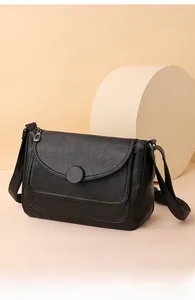 Dettaglio della borsa in pelle PU nera con trama litchi e fibbia rotonda decorativa