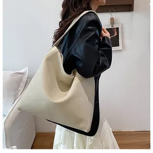 Detalle del bolso tote crema suave con textura de cuero granulado y diseño de correa ancha