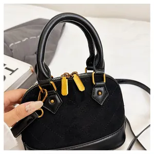 Détail du sac coquillage noir matelassé avec double fermeture éclair dorée élégante