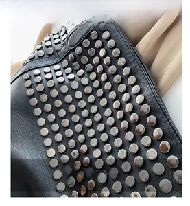 Close-up of black leather tote bag with dense silver metal rivet studs decoration