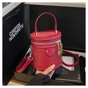 Detailansicht der roten geflochtenen Beuteltasche mit goldenem Schloss auf Geschenkbox