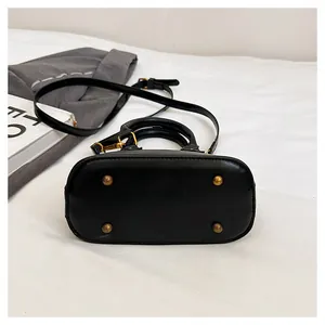 Vue détaillée du fond du sac montrant les clous dorés et la texture du cuir PU lisse