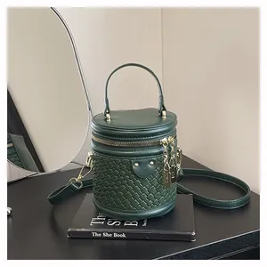 Detail der dunkelgrünen Eimertasche mit Webstruktur und goldenem Vorhängeschloss