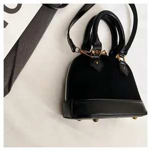 Gros plan du sac coquille matelassé noir montrant la texture daim et les détails dorés