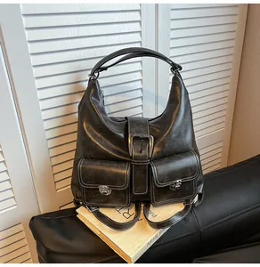 Detail view of dark grey vintage tote bag with metal buckles and white contrast stitching