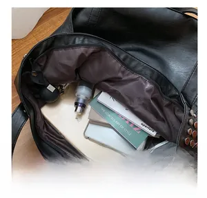 Top view detail of a spacious studded tote bag showing iPad, books, and umbrella storage