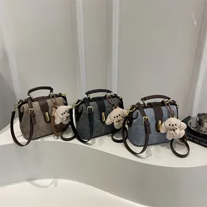 Chic quilted doctor bag in oatmeal, grey, and denim with plush puppy charm and chain strap