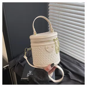 Detail der cremefarbenen Beuteltasche mit Flechtstruktur, Goldreißverschluss und Griff