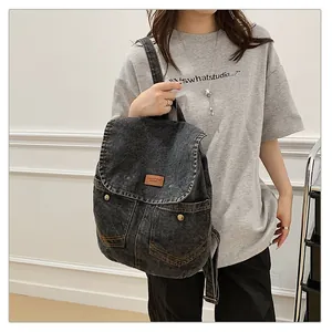 Washed denim backpack in black with front pockets and leather patch for women