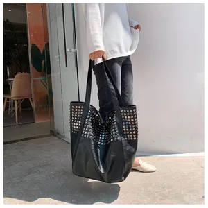 Detail of silver rivets on black large capacity faux leather tote bag for women