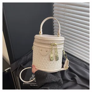Detail der cremefarbenen Beuteltasche mit Flechtstruktur, Doppelreißverschluss und Griff