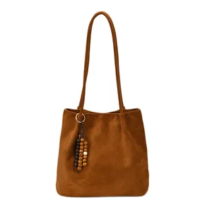 Retro brown faux suede tote bag with wooden bead tassel charm on white background