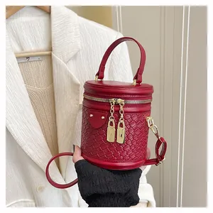 Detail der roten Zylindertasche mit Webstruktur und goldenem Vorhängeschloss-Zipper