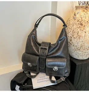 Detailed view of vintage hobo bag with contrast stitching and dual buckle front pockets