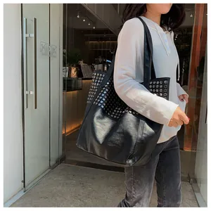 Detailed view of black rivet tote bag showing large capacity and silver studded texture