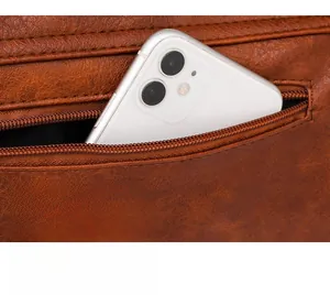 Dettaglio della tasca posteriore con zip di una borsa in pelle marrone e capienza