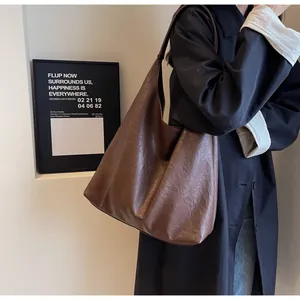 Side view of large dark coffee faux leather hobo bag for women in office setting