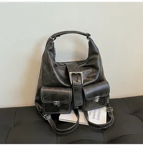 Detail of vintage black PU leather tote with white contrast stitching and silver buckles