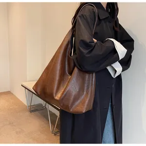 Detailed view showing the soft brown leather texture and stitching of the large tote bag